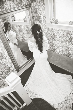 Black and white image of bride looking in the mirror