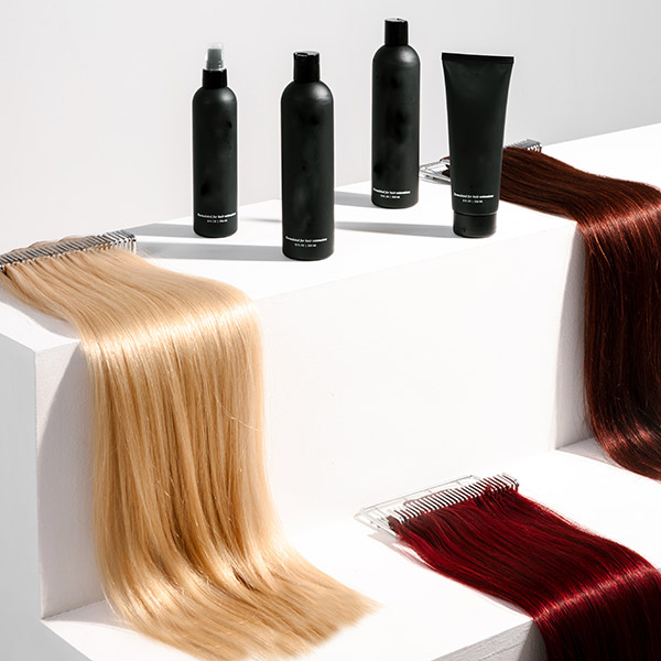 Three extensions laid out next to salon bottles